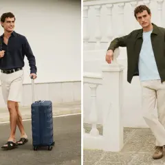 Mężczyzna w stylizacji smart casual, w granatowej koszuli i beżowych szortach, ciągnie walizkę. Obok, w zielonej kurtce i lnianych spodniach.